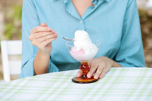 A girl eating an ice cream sundae, hands close up