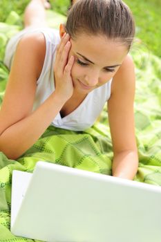 Cheerful girl working in laptop outdoors in a sunny day