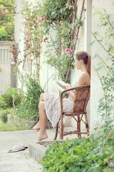Beautiful girl reading a book outdoors enjoying a summer day