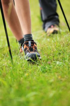 Woman hiking and nordic walking in forest. Sport shoe close up