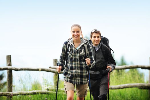 Young cheerful couple enjoying a nordic walk 