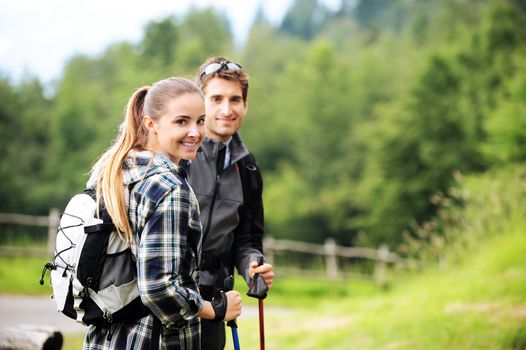 Young cheerful couple enjoying a nordic walk 