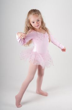 Studio shot of ballet dancer girl in pink doing pas