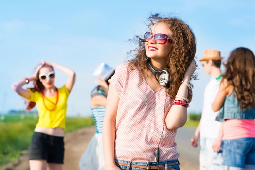 young woman with headphones on a background of blue sky and funny friends