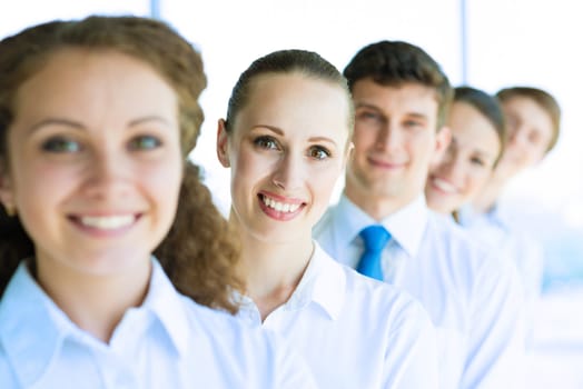 portrait of a young business woman standing in line with colleagues, concept of teamwork