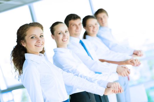 young business people holding hands, standing in a row, the concept of teamwork