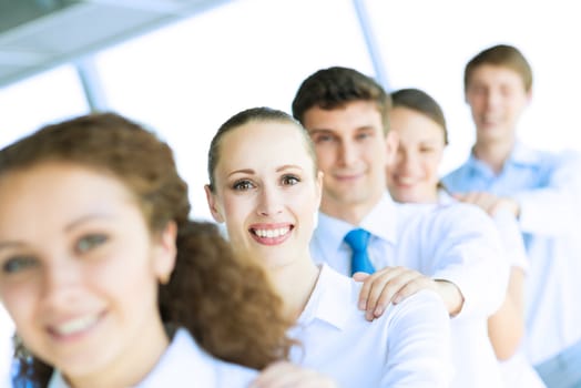 portrait of a young business woman standing in line with colleagues, concept of teamwork