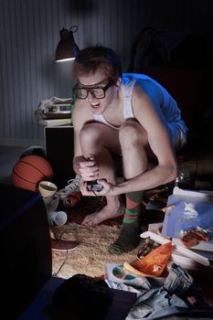 A excited teen plays video console games on His television
