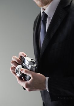 An elegant businessman holding a vintage camera