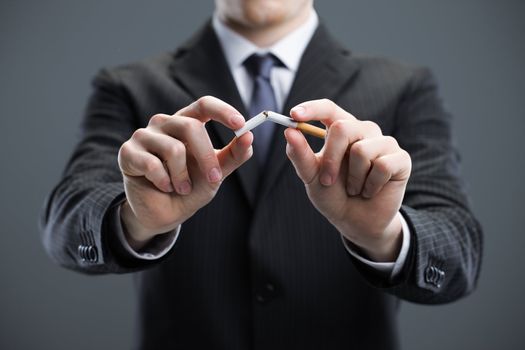 Human hands breaking cigarette 