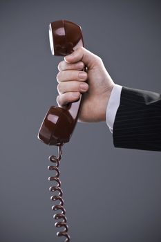 Businessman holding out a red phone, hand close up