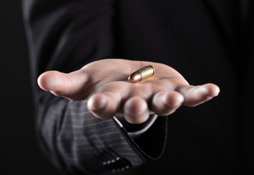 Male hand close up holding a bullet