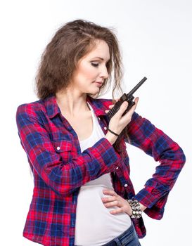 Attractive young woman in a checkered shirt with walkie talkie, isolated