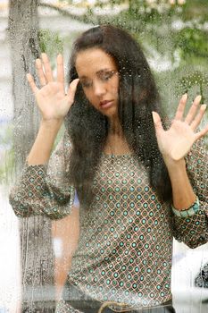 Portrait of a young woman near the window after the rain