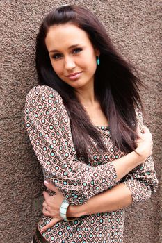 Young woman standing against white wall