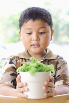 The boy is happy. With small trees.