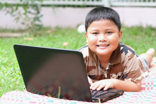 Boy playing laptop. Happily.