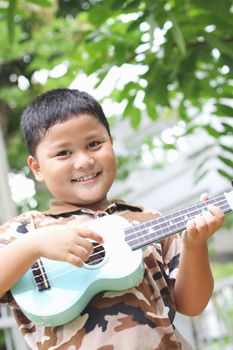 Boy playing the ukulele fun.