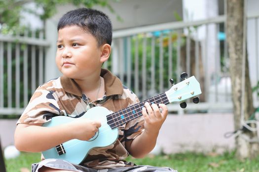 Boy playing the ukulele fun.