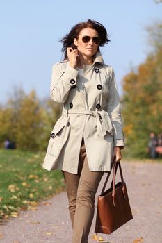 Full length, walking woman in autumn park
