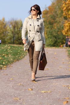 Full length, walking woman in autumn park