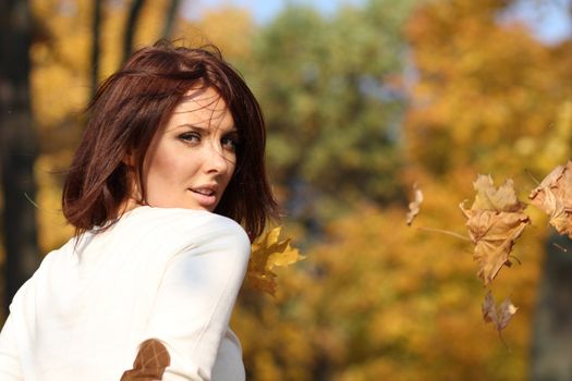 Portrait of a happy woman against yellow leaves