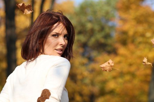 Portrait of a happy woman against yellow leaves