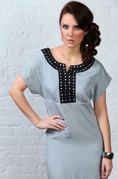 Young woman in fashion dress. Isolated over grey background.