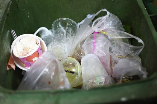 overflowing green garbage bin