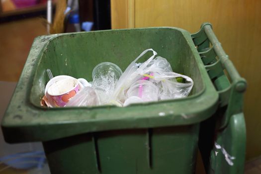 overflowing green garbage bin