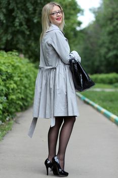 beautiful young woman business woman in a gray cloak