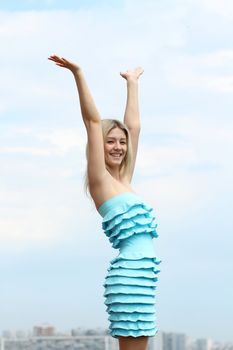 Young blond woman in sexy dress on background of the sky