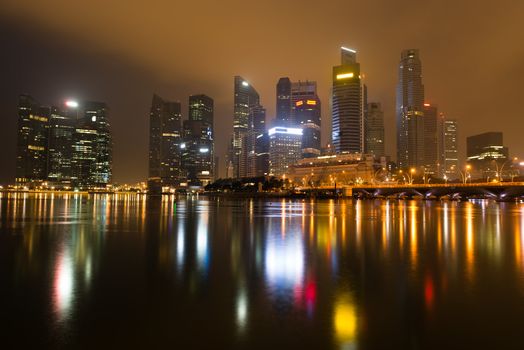 Modern city skyline of business district downtown in night with yellow glow