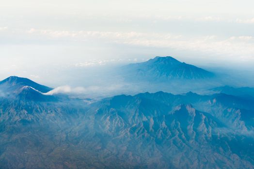 Volcano tops with smoke under sky, bird's eye view. Java island, Indonesia