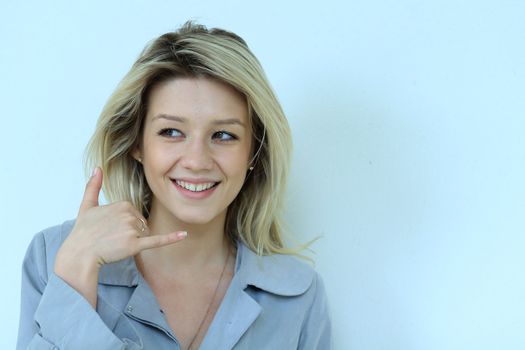 Beautiful woman making a call me gesture