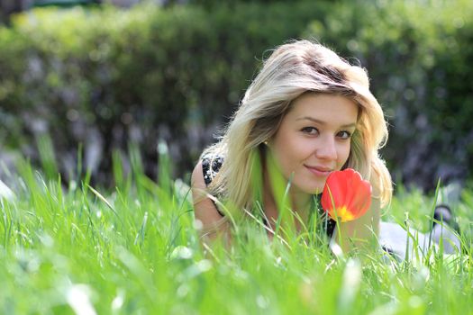 Cute young female lying on grass field at the park