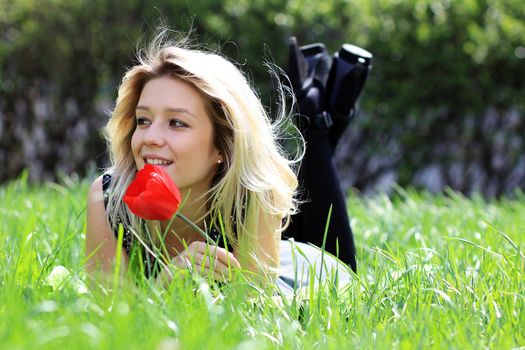 Cute young female lying on grass field at the park