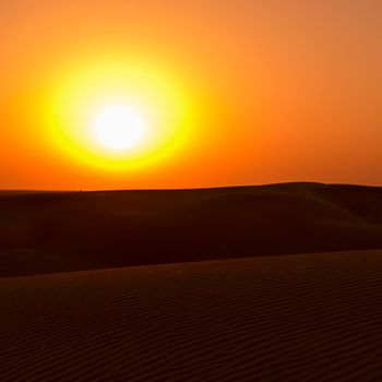 Big yellow sun under sand dunes in desert at sunset. Thar desert or Great Indian desert.