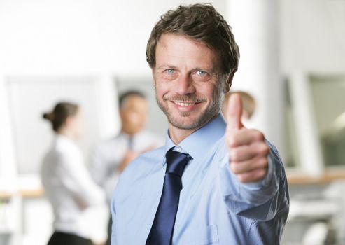Happy businessman showing thumbs up sign