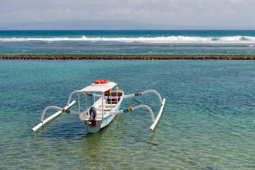 Traditional wooden fishing boats on a clean blue sea water on Bali. Indonesia. 