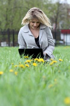 young blond having fun with laptop outdoors