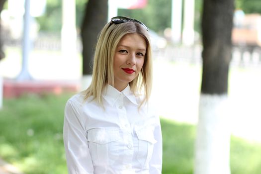 Portrait of young businesswoman standing in sunny park