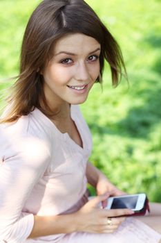 Portrait of young woman sitting in the summer park