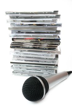 Microphone and karaoke compact disc collection on white background