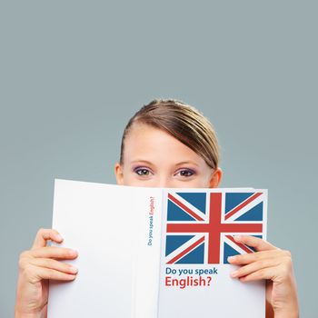 English female student hiding herself behind a book
