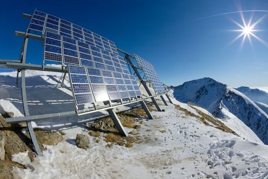 Big cluster of solar panels on a mountain peak