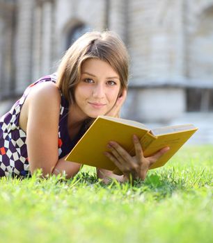 Young beautiful girl reading a book outdoor