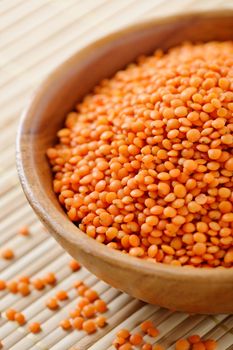 Closeup of wooden bowl full of red lentils