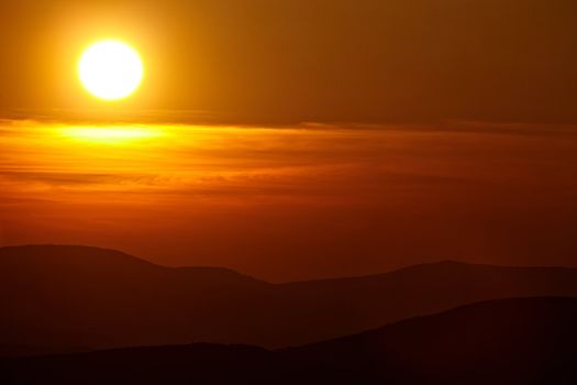 Setting sun in cloudy sky