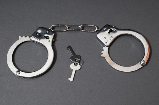 One Pair of Handcuffs on a Colored Background